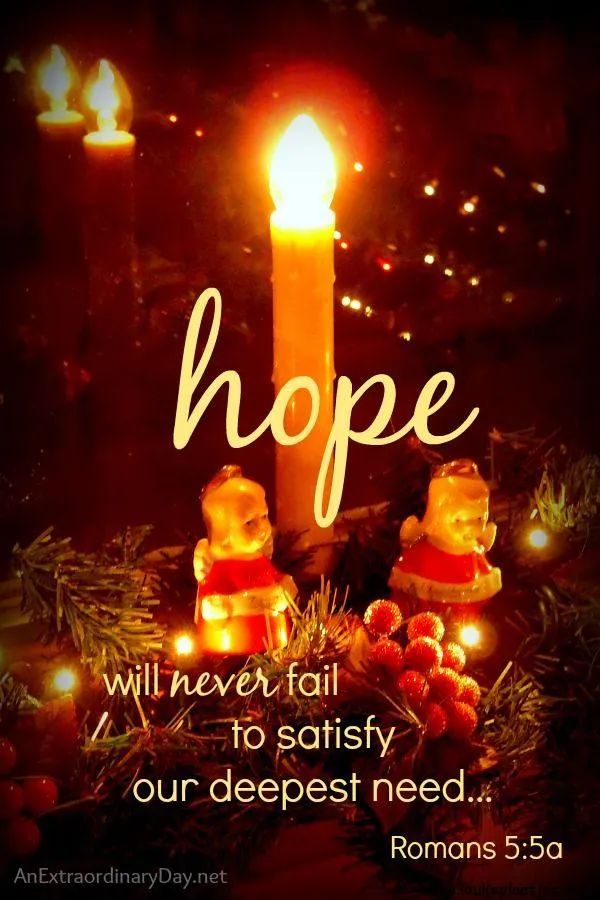 Kaars en kerstdecoraties met de tekst "hoop zal nooit falen." Romans 5:5a.