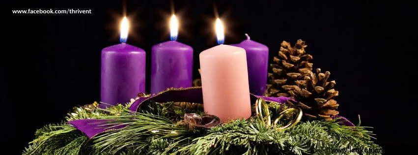 Vier brandende kaarsen op een kerstkrans met dennenappels en groen.