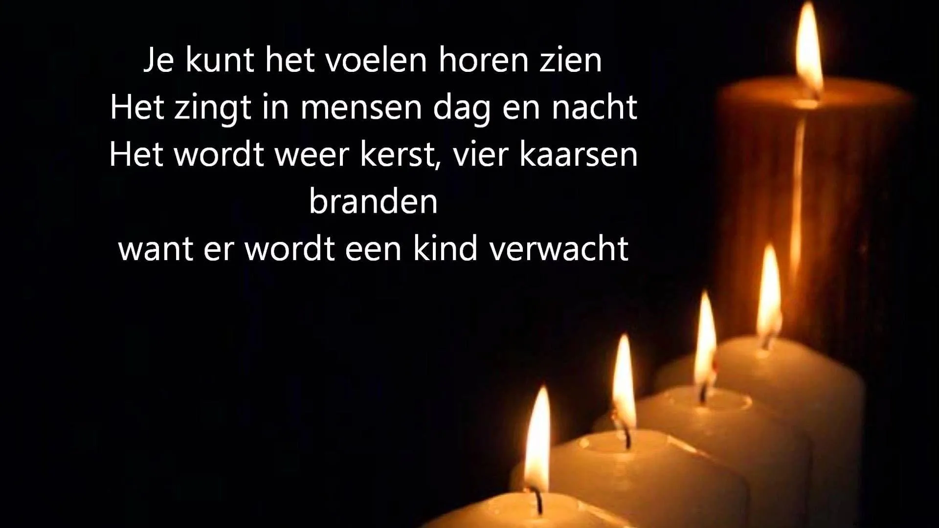Vier kaarsen branden op een tafel, de achtergrond is donker en sfeervol.