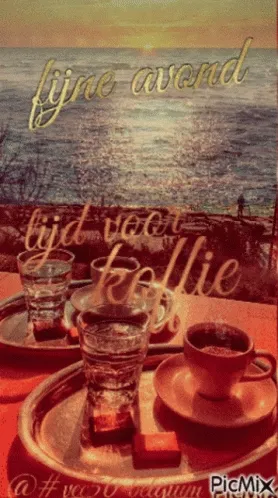 ᐅ fijne avond gif - Fijne avond plaatjes Twee kopjes koffie met glazen water en uitzicht op de oceaan bij zonsondergang.