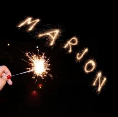 Hand met een sterretje waarbij de naam "MARJON" in het lucht wordt geschreven.