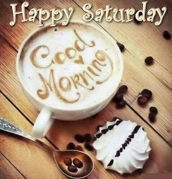 Een kop koffie met 'Goedemorgen' en een koekje op een houten tafel.