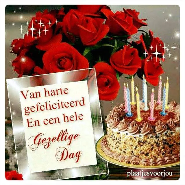 Een feestelijke taarten met kaarsjes, omringd door rode rozen en een felicitatie.