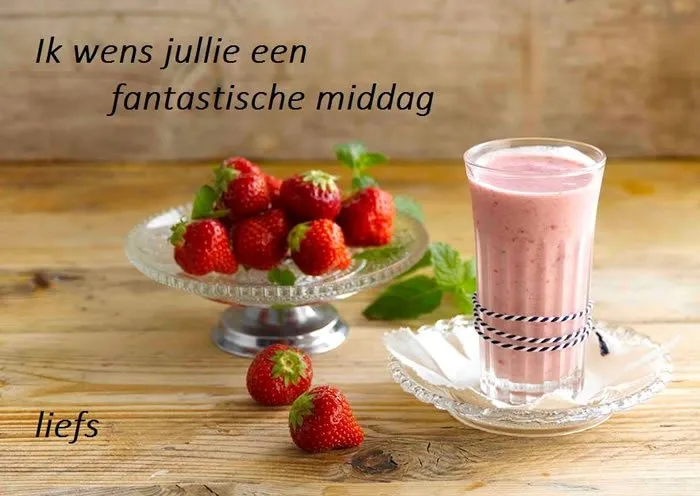 Een glas smoothie met aardbeien en een tekstwens op een houten tafel.