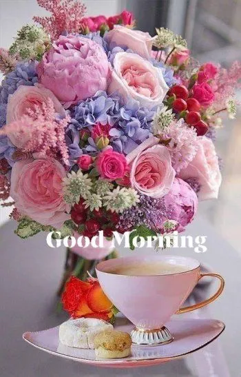 Een boeket bloemen naast een kopje thee en koekjes op een tafel. Goede morgen tekst.