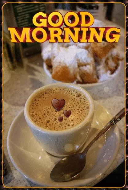 Witte kopje koffie met hartjes, op een tafel naast zoet gebak. Goede morgen!