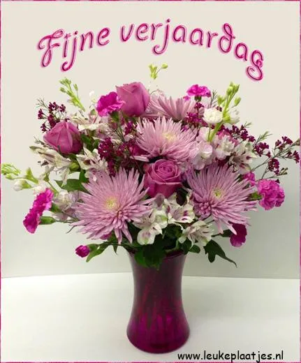 Een boeket met paarse bloemen in een vaas, met de tekst "Fijne verjaardag."