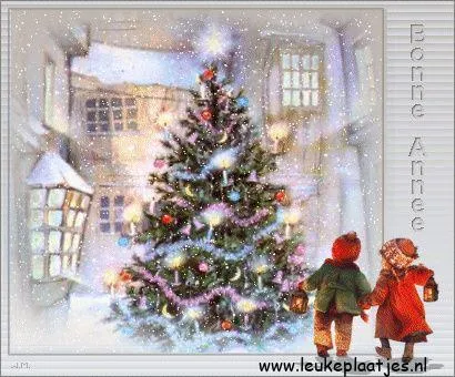 ᐅ kerstmis foto - Kerst plaatjes Twee kinderen met lantaarns staan naast een versierde kerstboom in de sneeuw.