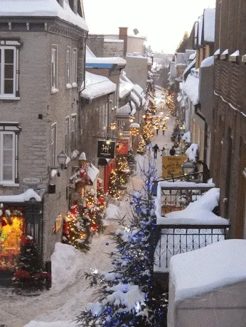 ᐅ koffie plaatje winter - Winter plaatjes Sneeuwbedekte straat met kerstversiering en winkelramen in een pittoresk dorp.