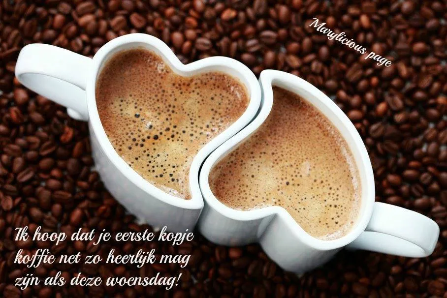 Twee hartvormige kopjes koffie naast elkaar op een ondergrond van koffiebonen.