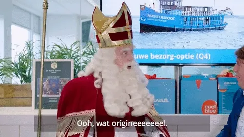 Een man in een koninklijk kostuum spreekt in een moderne ruimte.