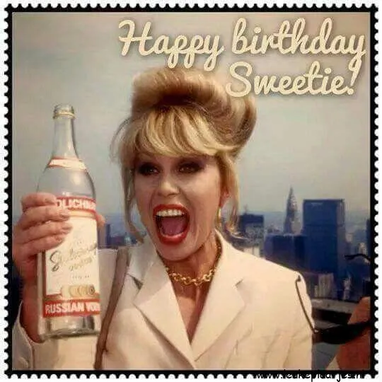 Vrouw met blond haar, houdt een fles drank vast en lacht, met skyline op de achtergrond.