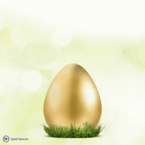 Gouden ei op gras met een lichte groene achtergrond.